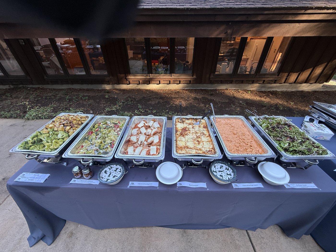 A full catering buffet with hot dishes and salads arranged for a group meal