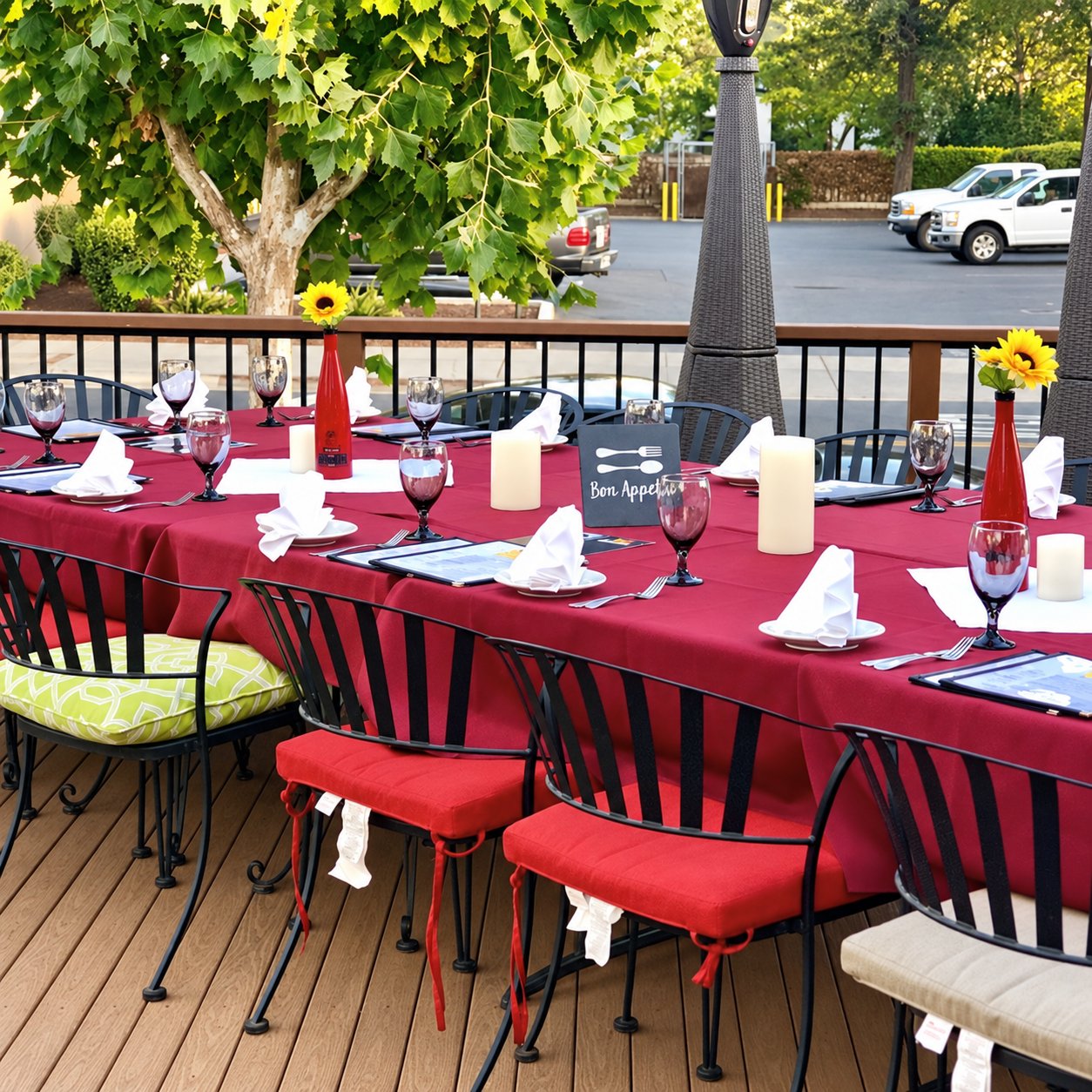 Sicilia In Bocca patio tables with burgundy linens, sunflowers and place settings